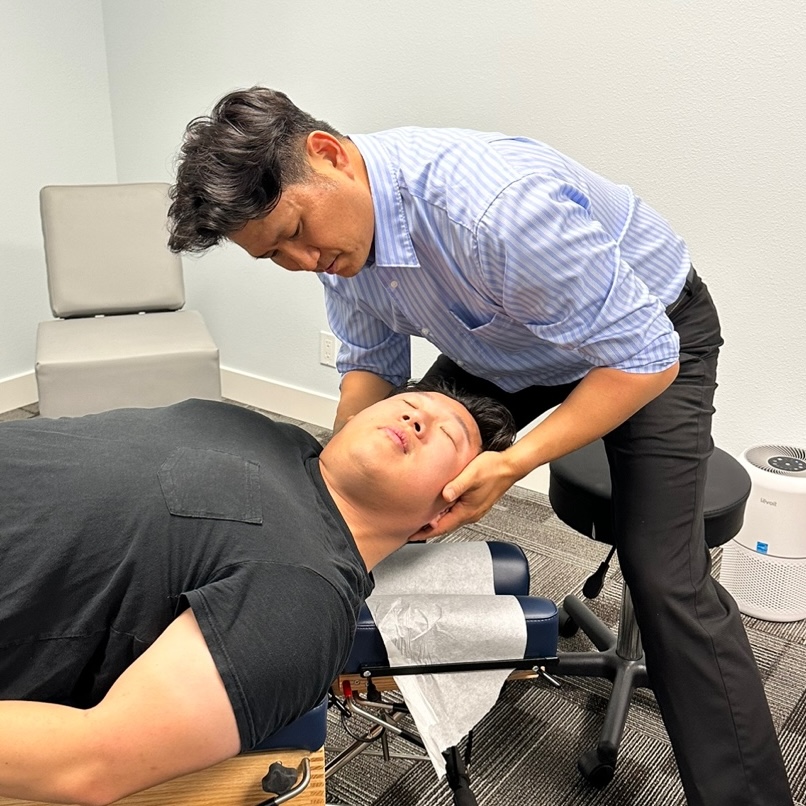 Jae ho Roh, D.C. giving patient neck pain treatment